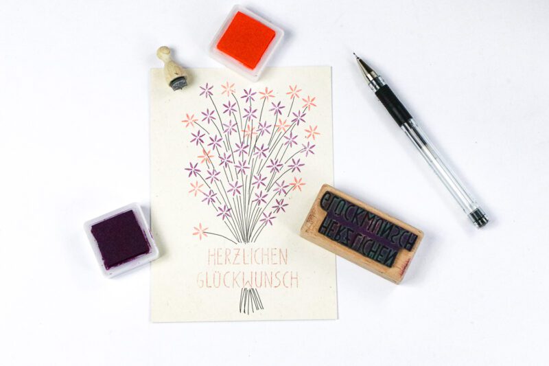 Selbst gestaltete Glückwunschkarte mit Textstempel Herzlichen Glückwunsch und Blumenstempeln
